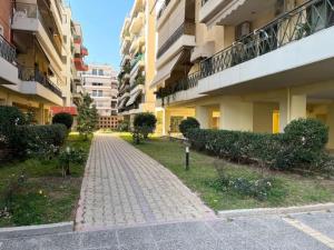 ceglany chodnik pomiędzy dwoma budynkami apartamentowymi w obiekcie Athens Riviera modern apartment w Pireusie