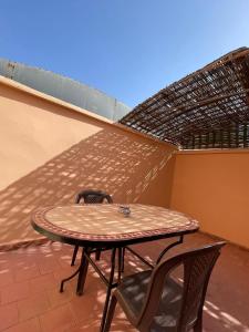 einen Tisch und zwei Stühle auf einer Terrasse in der Unterkunft Riad NEJJARINE in Marrakesch