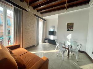 - un salon avec un canapé et une table en verre dans l'établissement Eva Recommends Triana, à Séville