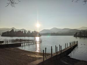 a sun setting over a body of water with a dock at Avondale Guest House in Keswick