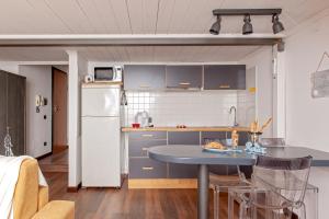 una cocina con armarios azules y una mesa con sillas en Sea Breeze Loft, en Livorno