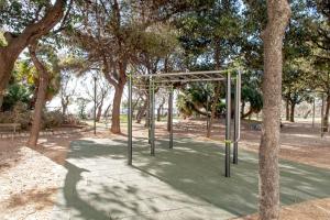 un parque con columpios a la sombra de los árboles en Sea Breeze Loft, en Livorno