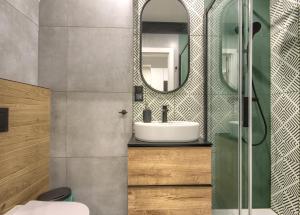 een badkamer met een wastafel en een spiegel bij Studio Bueno 5.1. - ACCO RENT in Gdańsk