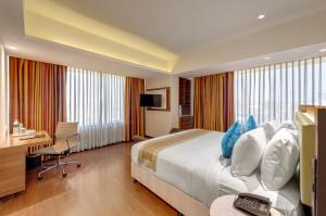 una camera d'albergo con letto, scrivania e computer di Amarpreet, Chhatrapati Sambhajinagar - AM Hotel Kollection ad Aurangabad
