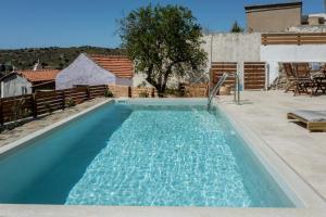 a swimming pool with blue water in a backyard at Nomas Home Skaloti with Private Pool in Skalotí