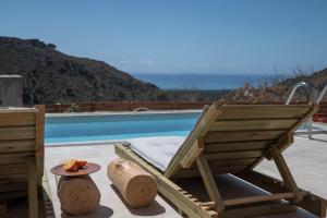 a wooden lounge chair sitting next to a swimming pool at Nomas Home Skaloti with Private Pool in Skalotí