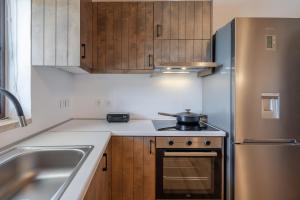 a small kitchen with a stove and a refrigerator at Nomas Home Skaloti with Private Pool in Skalotí +21 photos