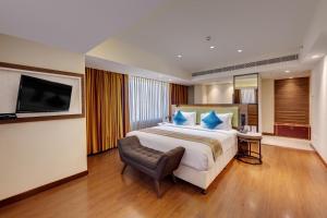 a hotel room with a large bed and a flat screen tv at Amarpreet, Chhatrapati Sambhajinagar - AM Hotel Kollection in Aurangabad
