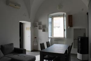 ein Wohnzimmer mit einem Tisch, einem Sofa und einem Fenster in der Unterkunft Da Nonna Concettina by Salento com in Aradeo
