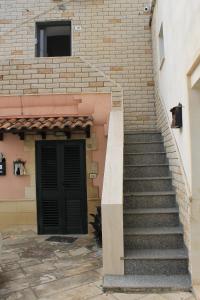 eine Treppe, die zu einem Gebäude mit einer Tür führt in der Unterkunft Da Nonna Concettina by Salento com in Aradeo