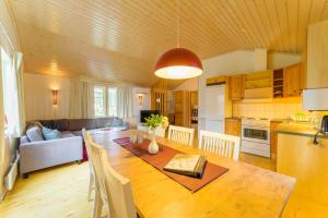 a kitchen and living room with a wooden table and a dining room at Byske Havsbad in Byske