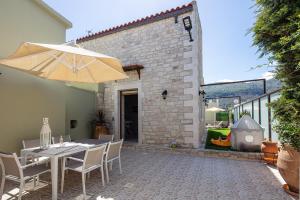 a patio with a table and an umbrella at Sokaki Villas, rustic ambience, By ThinkVilla in Khromonastírion