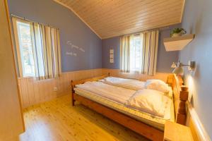 um quarto com uma cama num quarto com janelas em Byske Havsbad em Byske