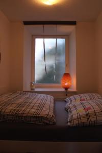 1 dormitorio con 2 camas, ventana y lámpara en Ferienwohnung im Alten Peter, en Goslar
