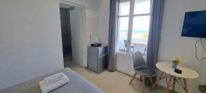 a room with a bed and a table and a window at Fabrica Sunset Apartments in Megali Ammos