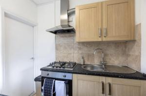 a kitchen with a sink and a stove at Luxury 3 bedroomed home in Kettering
