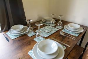 una mesa de madera con platos y copas de vino. en Newly Refurbished Homely 4BR in Sherwood, en Nottingham