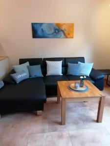 a living room with a black couch and a wooden table at Ferienwohnung Katharina in Bernkastel-Kues