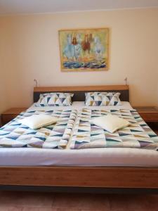 a large bed in a bedroom with a painting on the wall at Ferienwohnung Katharina in Bernkastel-Kues