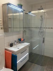 a bathroom with a sink and a shower with a glass door at Ferienwohnung Katharina in Bernkastel-Kues