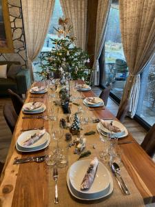 a long wooden table with a christmas tree on it at Mountain Chalets Valča -hobitie domy in Stará Turá