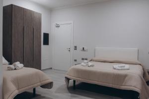 a white bedroom with two beds and a closet at Prestige in Trevico