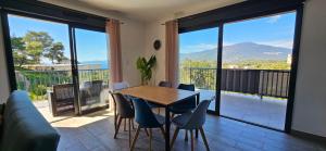 een eetkamer met een tafel en stoelen en een balkon bij Super T3 vue Mer et Montagne. Idéalement situé. in Propriano