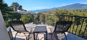 2 stoelen en een tafel op een balkon bij Super T3 vue Mer et Montagne. Idéalement situé. in Propriano