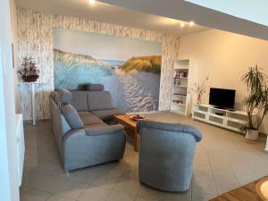 ein Wohnzimmer mit einem großen Gemälde eines Strandes in der Unterkunft Gästehaus Niederhof in Sundhagen-Niederhof