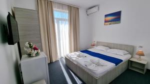 ein Hotelzimmer mit einem Bett und einem Fenster in der Unterkunft Neptun Resort in Eforie Nord