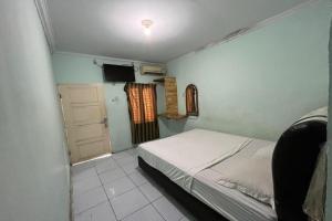 Dormitorio pequeño con cama y TV en SPOT ON 92481 Modena Homestay Syariah, en Medan