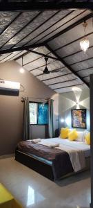 una camera da letto con un grande letto con cuscini gialli di Shankar Homestay a Hampi