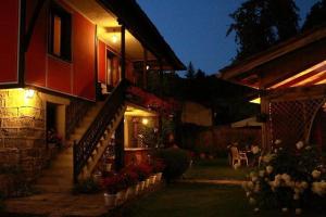 une maison avec un escalier et des fleurs dans une cour dans l'établissement Астра къща за гости, à Koprivchtitsa