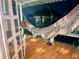 a hammock on a porch with a view of the water at Cabana Do Mar in Angra dos Reis