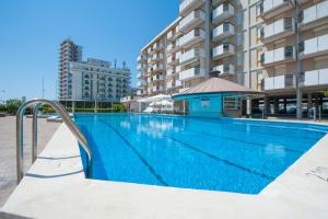 a swimming pool in front of a building at Residence Playa Grande Immobiliare Pacella in Lido di Jesolo