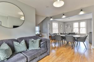 a living room with a couch and a dining room at Stylish and Spacious 3 Bed Apartment with Parking by Ark SA in Sheffield
