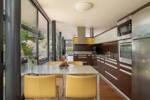 a kitchen with yellow chairs and a table at Villa 7 in Perivólia
