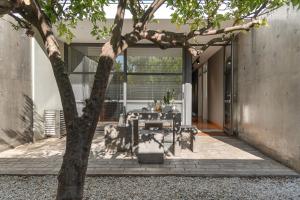 a patio with a table and a tree at Villa 7 in Perivólia