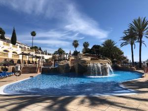 a swimming pool with a waterfall in a resort at Pool paradise in Calpe