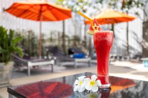 a drink sitting on top of a table with flowers at Citrus Patong Hotel by Compass Hospitality in Patong Beach