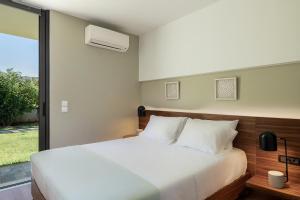 a bedroom with a white bed and a window at Villa 7 in Perivólia