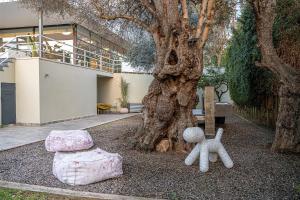 a tree with stuffed animals sitting next to a bench at Villa 7 in Perivólia