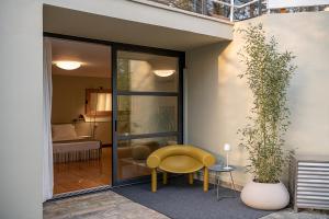 a yellow chair sitting next to a glass door at Villa 7 in Perivólia