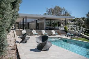 a house with a swimming pool and some chairs at Villa 7 in Perivólia
