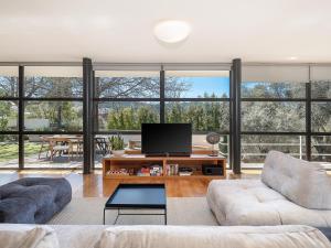 a living room with a tv and large windows at Villa 7 in Perivólia