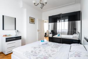 a bedroom with a large white bed and a mirror at Vitosha Str 2BD White & Blue Apt in Sofia