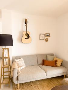 a living room with a couch and a guitar on the wall at Casa Arjuna in Valle Gran Rey