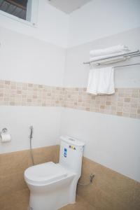 a bathroom with a toilet and towels in it at Hotel Span in Butwāl