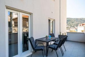 patio con mesa y sillas en el balcón en Apartment Olive 2 en Mokošica