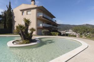 a house with a swimming pool in front of a house at Pool and sea views apartment with 1 parking space in Tossa de Mar